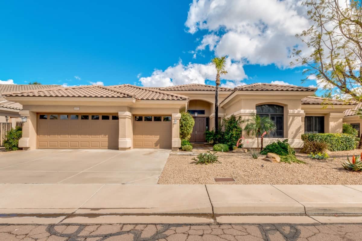 tan one story home with palm tree